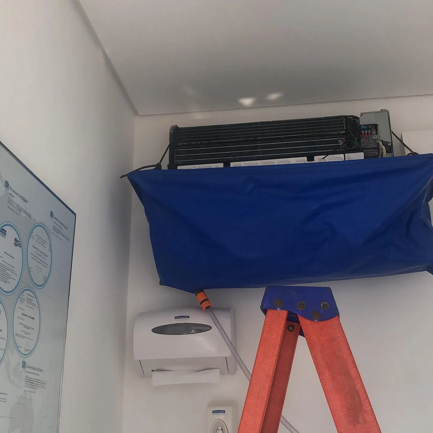 Split de um ambiente comercial com a bolsa coletora azul instalada para a higienização