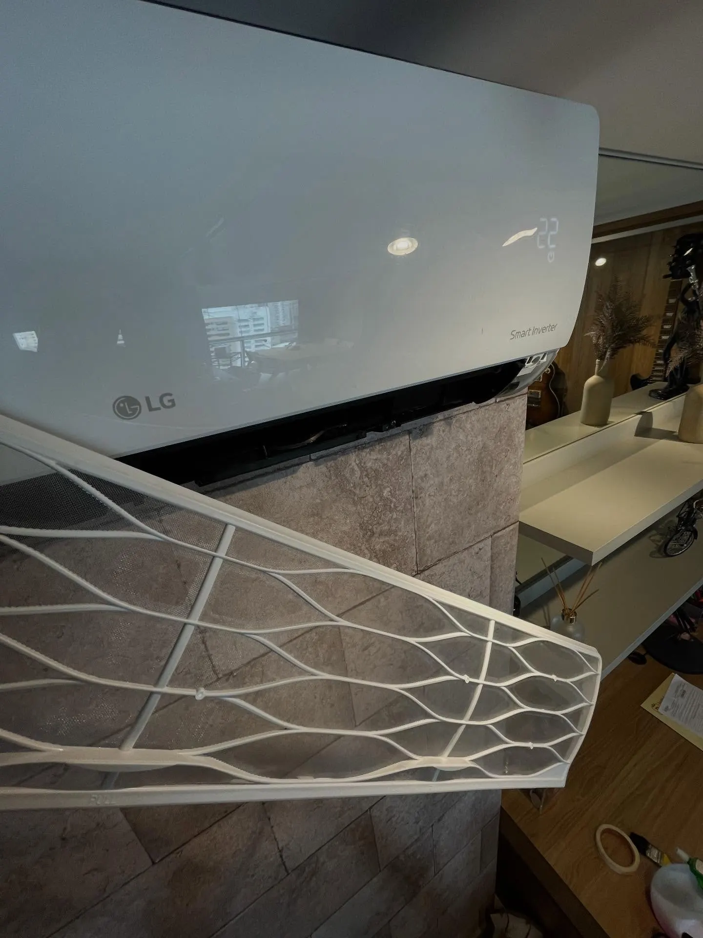 Split LG com o painel frontal aberto, durante o serviço