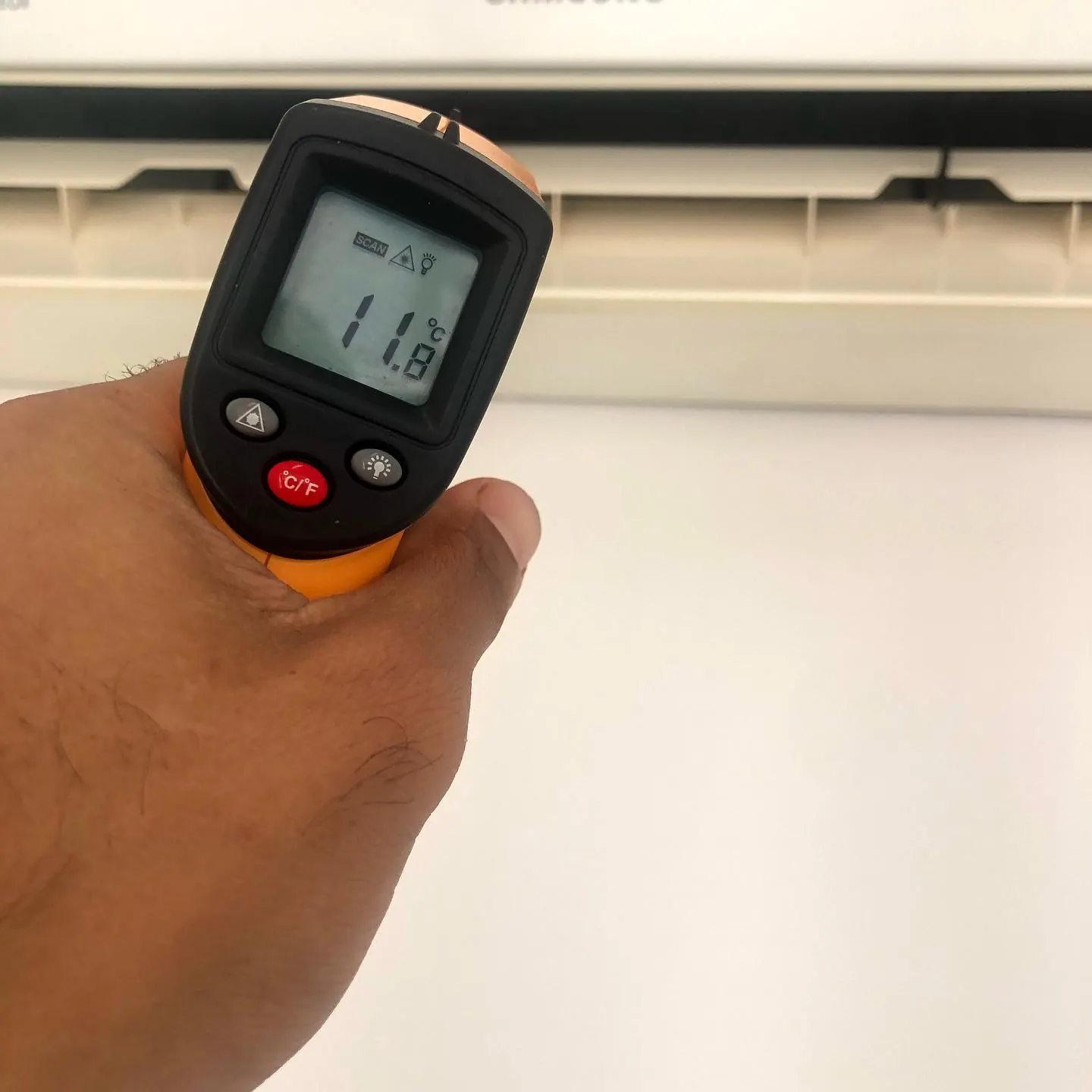 Termômetro infravermelho medindo a temperatura na saída de ar de um split